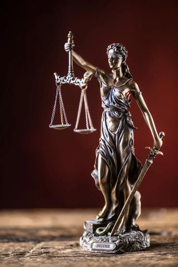 Estatua de la Justicia que sostiene una balanza y una espada, símbolo de imparcialidad y equilibrio en los casos de defensa contra la expulsión.